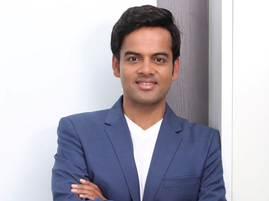 Anirudh A. Damani, Managing Partner at Artha Venture Fund, standing with a confident smile in a formal blue blazer.