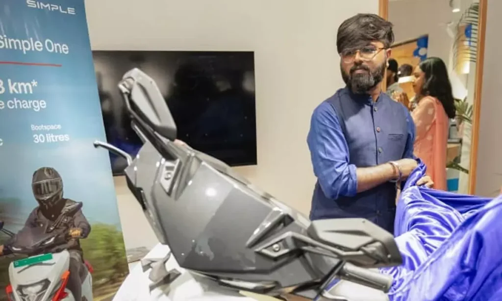 Simple One electric scooter being revealed by a company representative during the launch event.