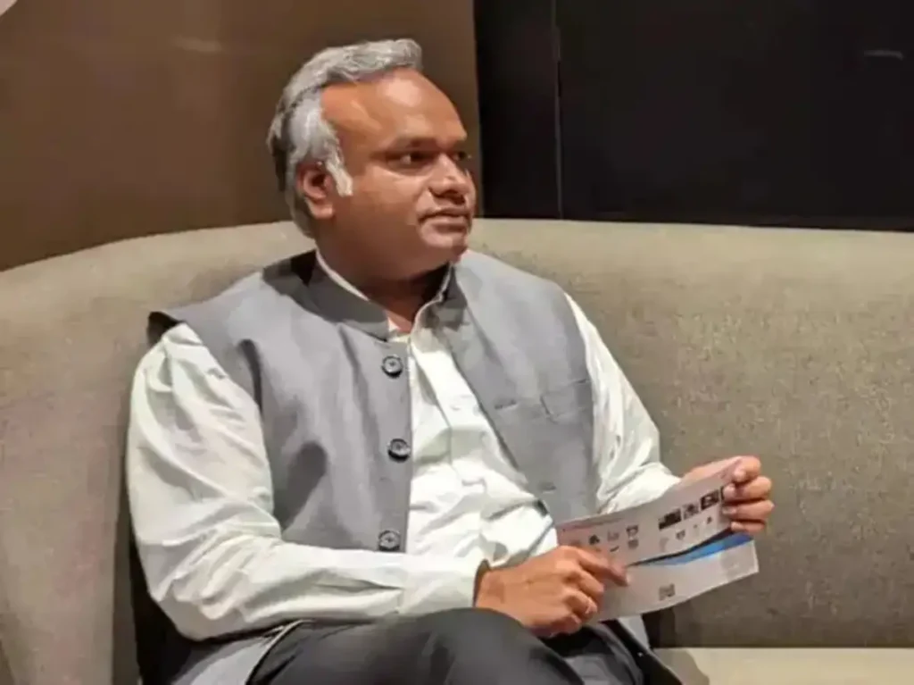 Karnataka Chief Minister Siddaramaiah seated indoors holding a document during a discussion.