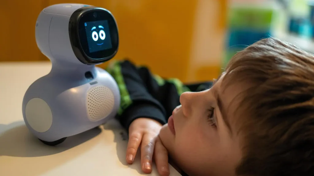 A child interacts closely with Miko, an AI-powered educational robot developed by Indian startup Miko to enhance learning through play and emotional engagement.