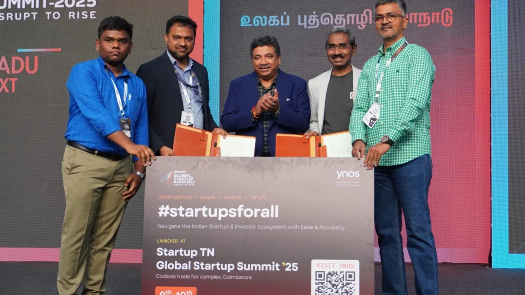 Group on stage holding folders beside a board reading “#startupsforall,” at the StartupTN Global Startup Summit 2025.
